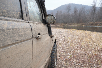 Part of an off-road car on the background of a river