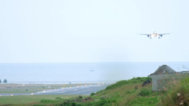 Front view of passenger plane approaching before landing. Runway on the background of the sea