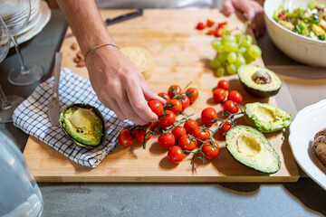 Man hand picking cherry tomato for his breakfast preparation