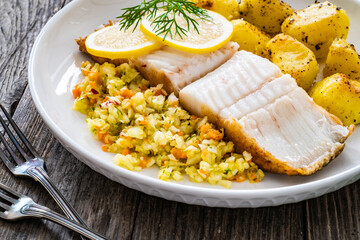 Fish dish - fried halibut with French fries and lemon on wooden table
 - obrazy, fototapety, plakaty