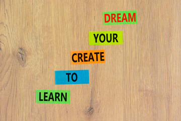Create your dream symbol. Concept words Learn to create your dream on colored paper. Beautiful wooden table wooden background. Business learn to create your dream concept. Copy space.