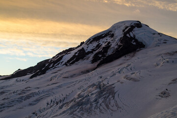 Sunrise colors on clouds behind Mount Baker