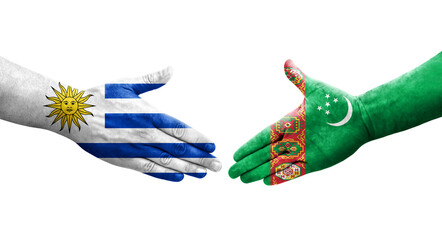 Handshake between Turkmenistan and Uruguay flags painted on hands, isolated transparent image.