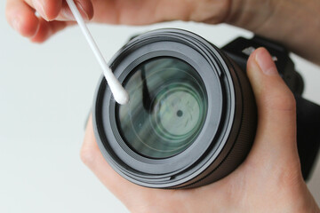Cleaning the camera lens with a cotton swab.