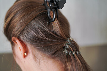 Fototapeta premium Gray hairs on the head of a young girl. Long gray hair. The initial stage of gray hair. The problem of gray hair in women.