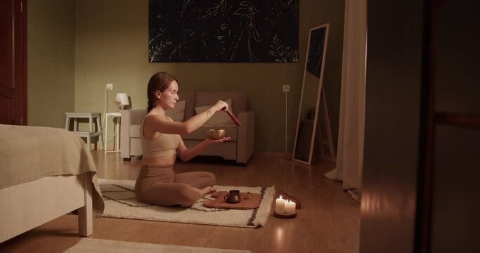 Woman playing singing bowl during yoga session
