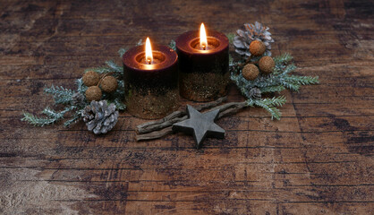Fototapeta na wymiar Kerzen mit Tannenzweigen und Weihnachtsdekoration auf einem alten Holzbrett mit Platz für Text.