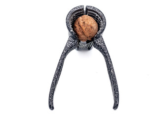 walnut and a metal walnut cracker on white background, isolated, close up 