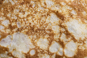 Pancake surface texture and pattern. Close-up of thin hot pancakes in a plate. Traditional rustic food. Graphic resource.