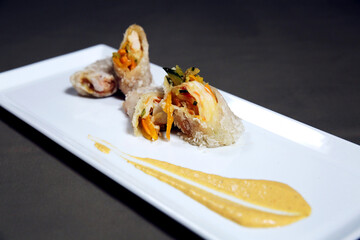 Spring rolls made of rice paper with shrimps, vegetables and sauce on a white plate. Fresh asian appetizer nems. Vietnamese Food