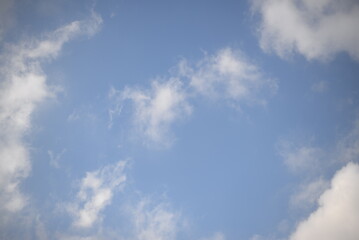 rays of the sun through cirrus clouds against a blue sky, white rainy clouds against a blue sky illuminated by the rays of the sun