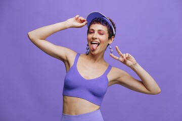 Fashion woman in bright purple sportswear portrait smiling and looking at camera on purple background and smiling