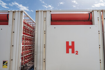 Truck with metal bottles joined by tubes used for the transport of hydrogen, H2, according to the ADR regulations for road transport.