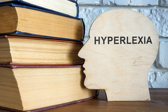 Wooden head with word hyperlexia and books.
