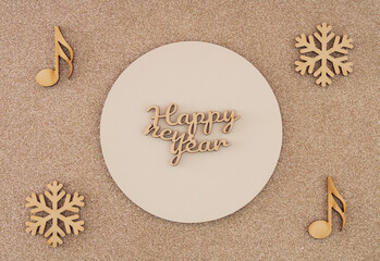 Fototapeta na wymiar Greeting card with text Happy New Year. Golden glittering background with wooden notes and snowflakes. Holiday concept. Flat lay.