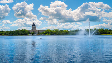Wascana Park panoramic landscape with lake, fountain and Saskatchewan Legislative Building in...