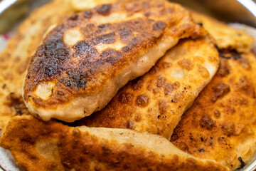 fried chebureks with meat in a frying pan
