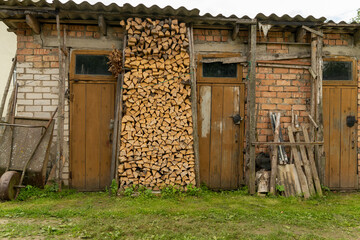 stacked firewood stored in wooden shed