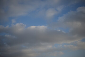 background of daytime cloudy sky white clouds rainy weather blue sky sun rays texture of sky and cirrus clouds in a city in Ukraine, atmosphere, peaceful sky stratosphere  before the rain 
