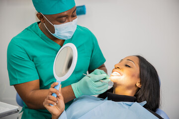 Patient looks at his teeth with the mirror during a dental visit