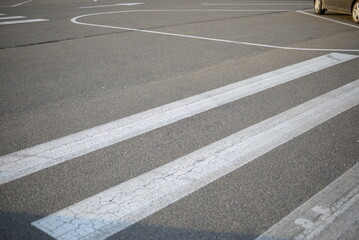 Obraz premium abstract lines pedestrian crossing background road markings white stripes on the asphalt road, parking spaces separated by white lines, symmetrical abstract lines on gray asphalt