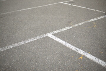 Fototapeta premium white lines abstract on asphalt, road markings white stripes on the asphalt road, parking spaces separated by white lines, symmetrical abstract lines on gray asphalt