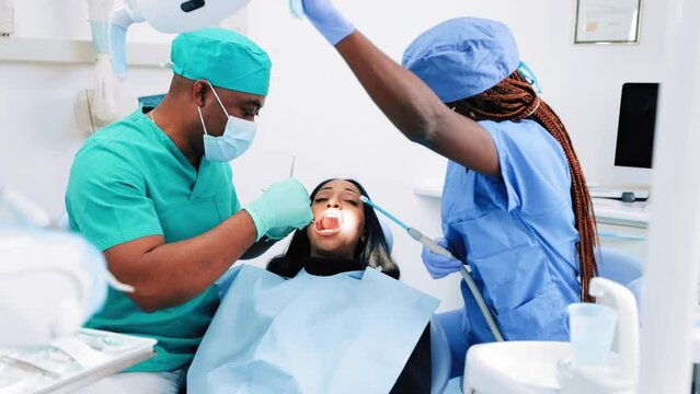 A doctor checking the teeth of an African patient.
