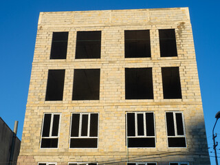 A five-story concrete block house under construction. The skeleton of the house. Unfinished construction of a small residential building.