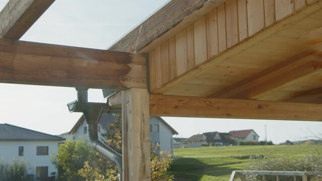 wooden sunshade construction and roof gutter on home terrace