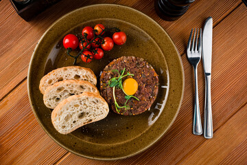 Beef steak tartare with raw egg yolk. French cuisine.