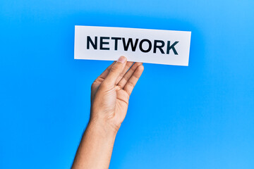 Hand of caucasian man holding paper with network word over isolated blue background