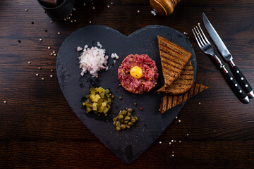Beef steak tartare with raw egg yolk. French cuisine.