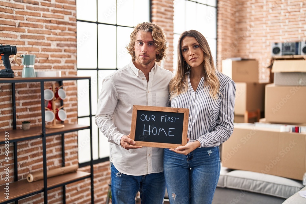 Poster Young couple moving to a new home relaxed with serious expression on face. simple and natural looking at the camera.