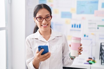 Young beautiful hispanic woman business worker using smartphone drinking coffee at office