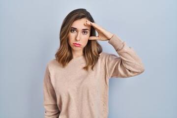 Young woman standing over isolated background worried and stressed about a problem with hand on forehead, nervous and anxious for crisis