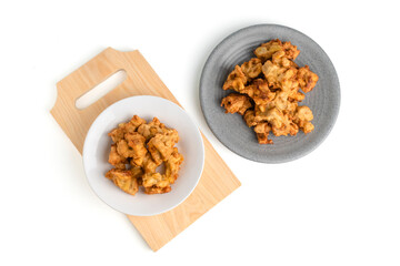 banana fritter or fried banana on a plate and wooden cutting board isolated on white background