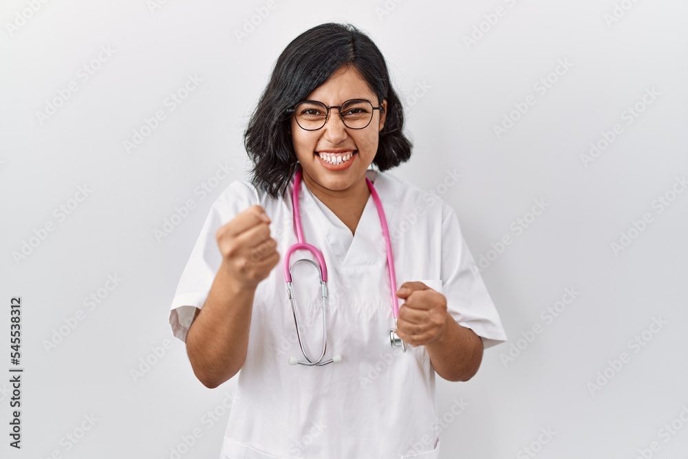 Sticker young hispanic doctor woman wearing stethoscope over isolated background very happy and excited doin