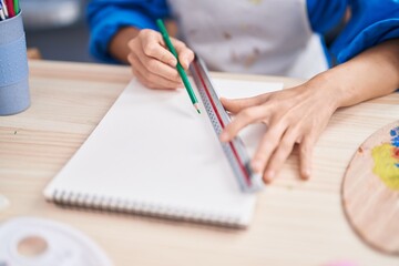 Young woman artist drawing on notebook at art studio