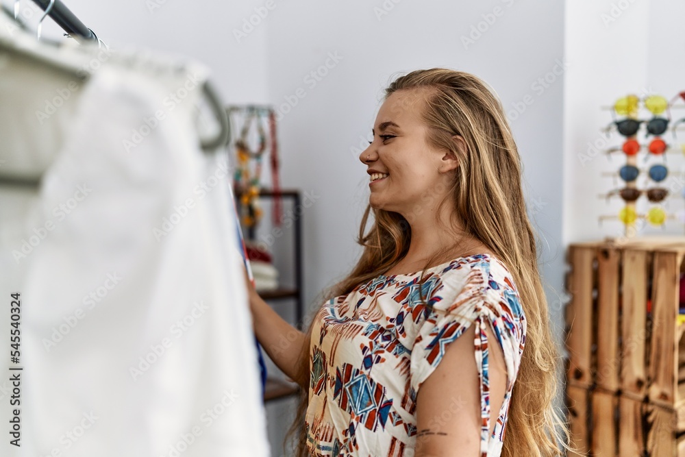 Poster Young blonde girl customer shopping at clothing store