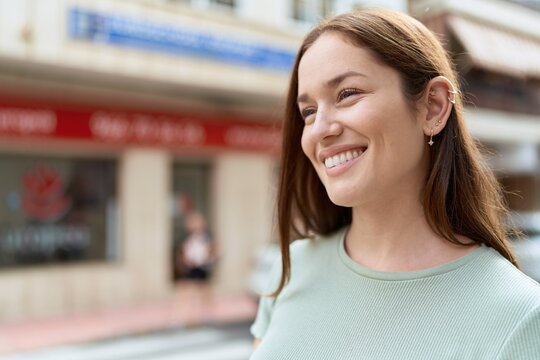 Young beautiful woman smiling confident looking to the side at street