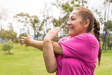 senior woman stretching her arms in the park
