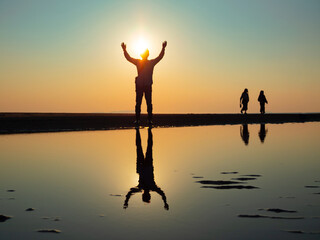 香川県・父母ヶ浜海岸にて夕日を背に立つ男性