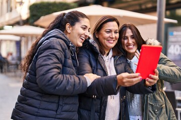 Three woman mother and daughters having video call at street