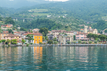 Panorama of the lakeside of Sulzano with colored houses that reflecting in the Lake Iseo