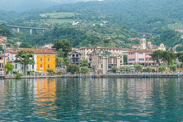 Panorama of the lakeside of Sulzano with colored houses that reflecting in the Lake Iseo