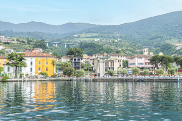 Panorama of the lakeside of Sulzano with colored houses that reflecting in the Lake Iseo