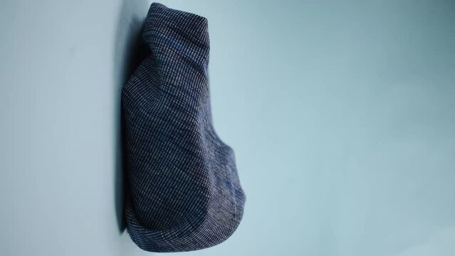 Vertical video of man hand taking a bright crown on blue background 