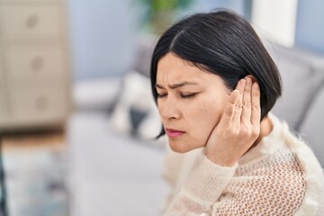 Young chinese woman suffering for earache at home