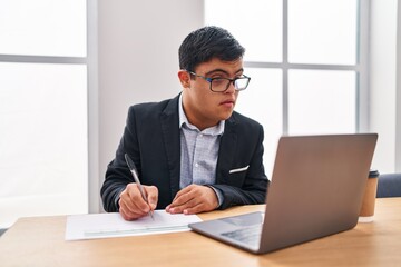 Fototapeta premium Down syndrome man business worker writing on document at office