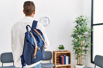 Young hispanic man waiting with student bag at waiting room